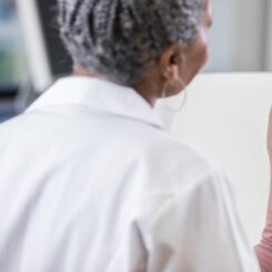 Cheerful patient talking with female doctor