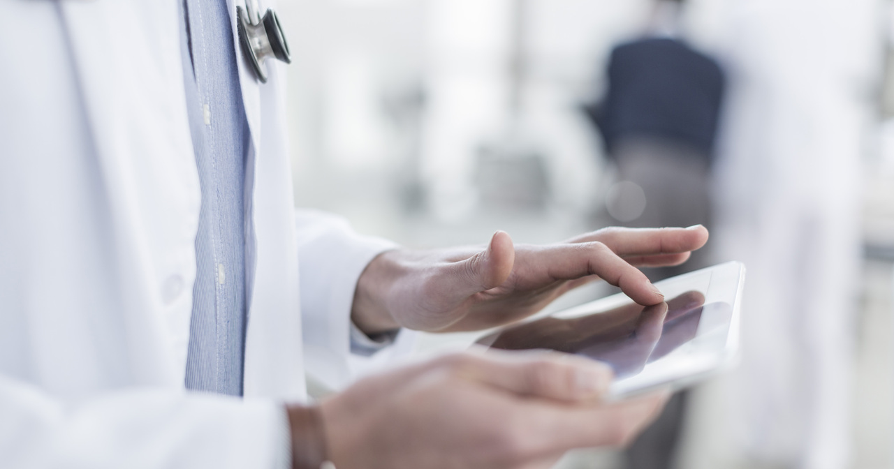 Close up of a male doctor using a digital tablet
