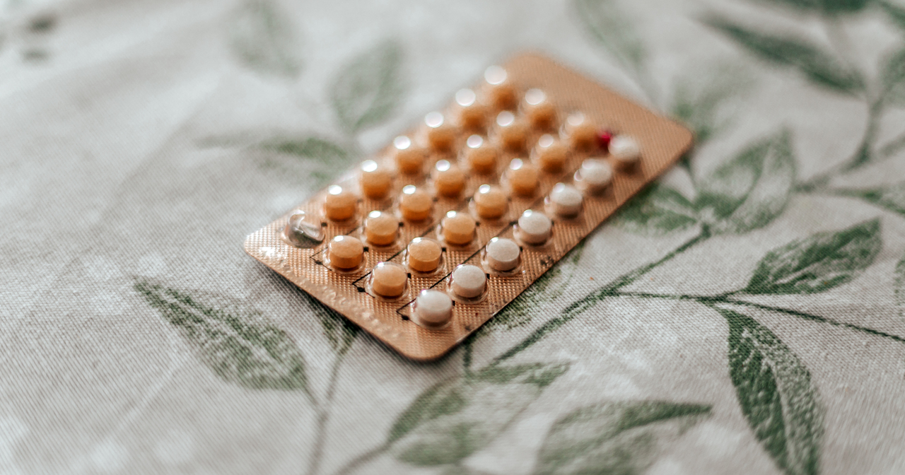 Birth control pill pack on a floral table cloth