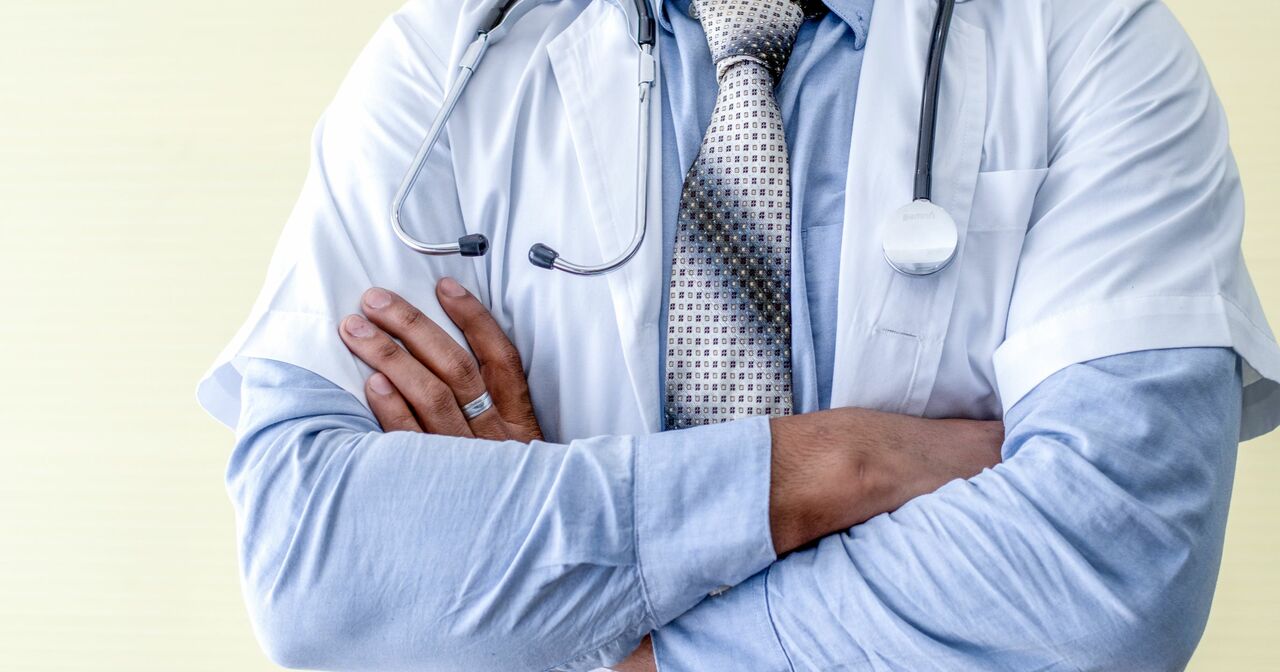 A close up of a male doctor with his arms crossed