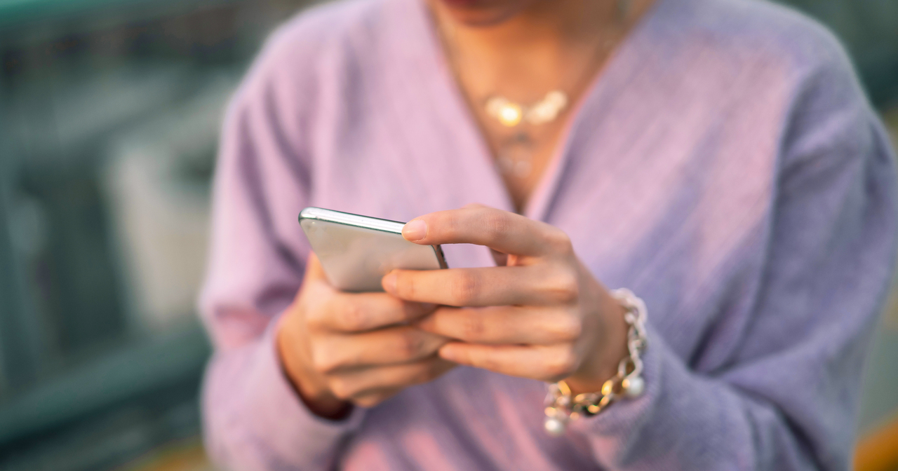 Young girl wearing purple using her cell phone