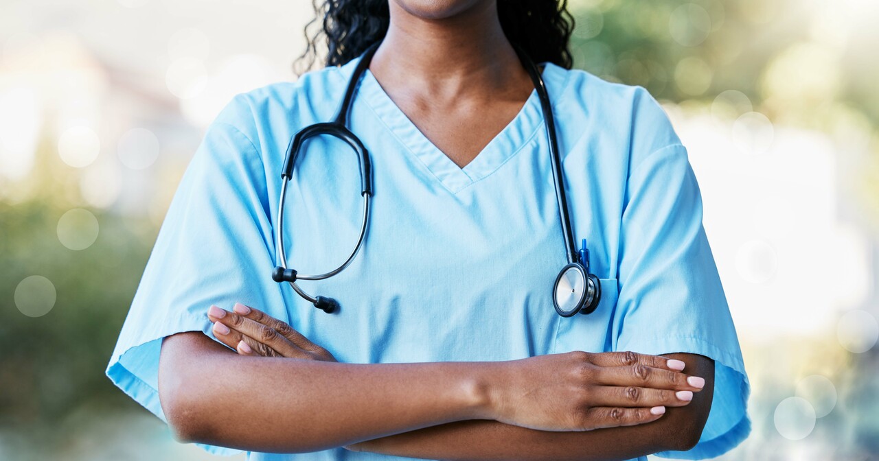 Provider in blue with a stethoscope, folding her arms powerfully across her chest