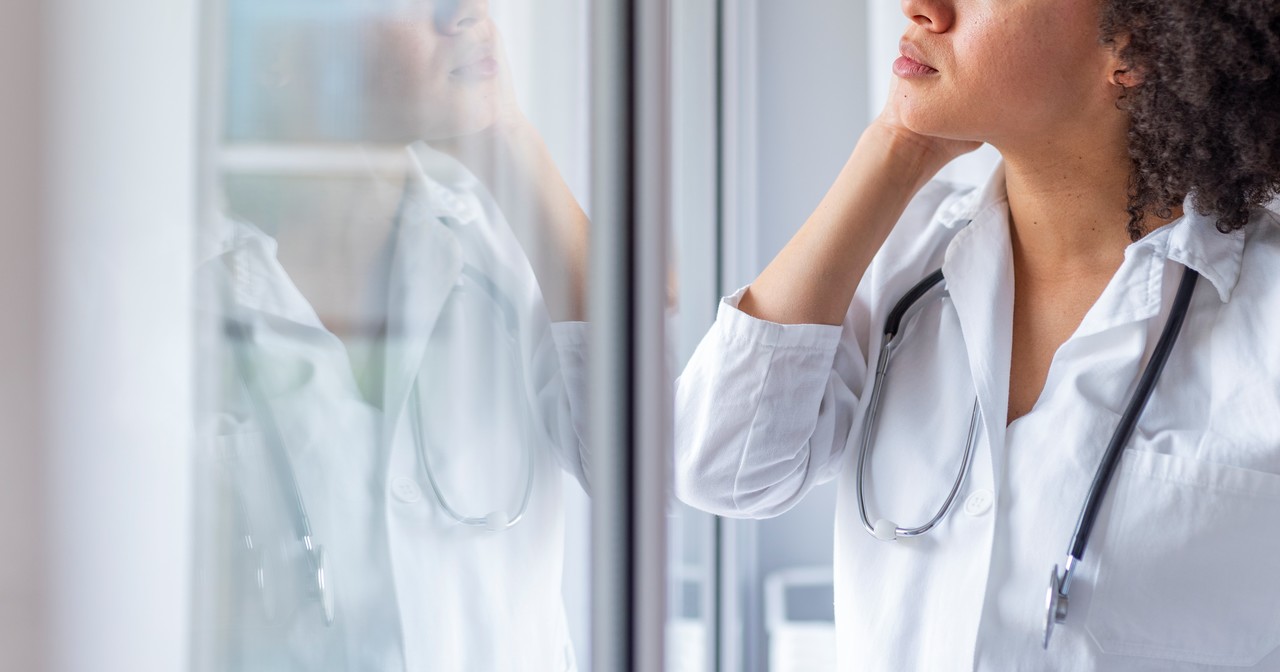 A female nurse staring contemplatively out a window