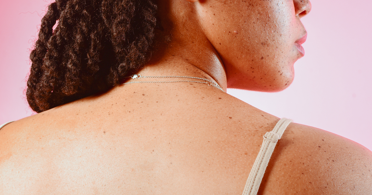 Back of a woman's shoulders and the profile of her thoughtful face and braided hair