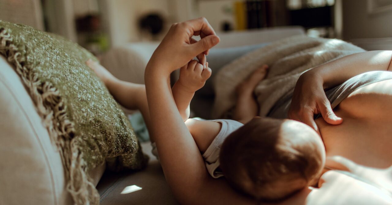 A mother breastfeeding her baby lying on her side