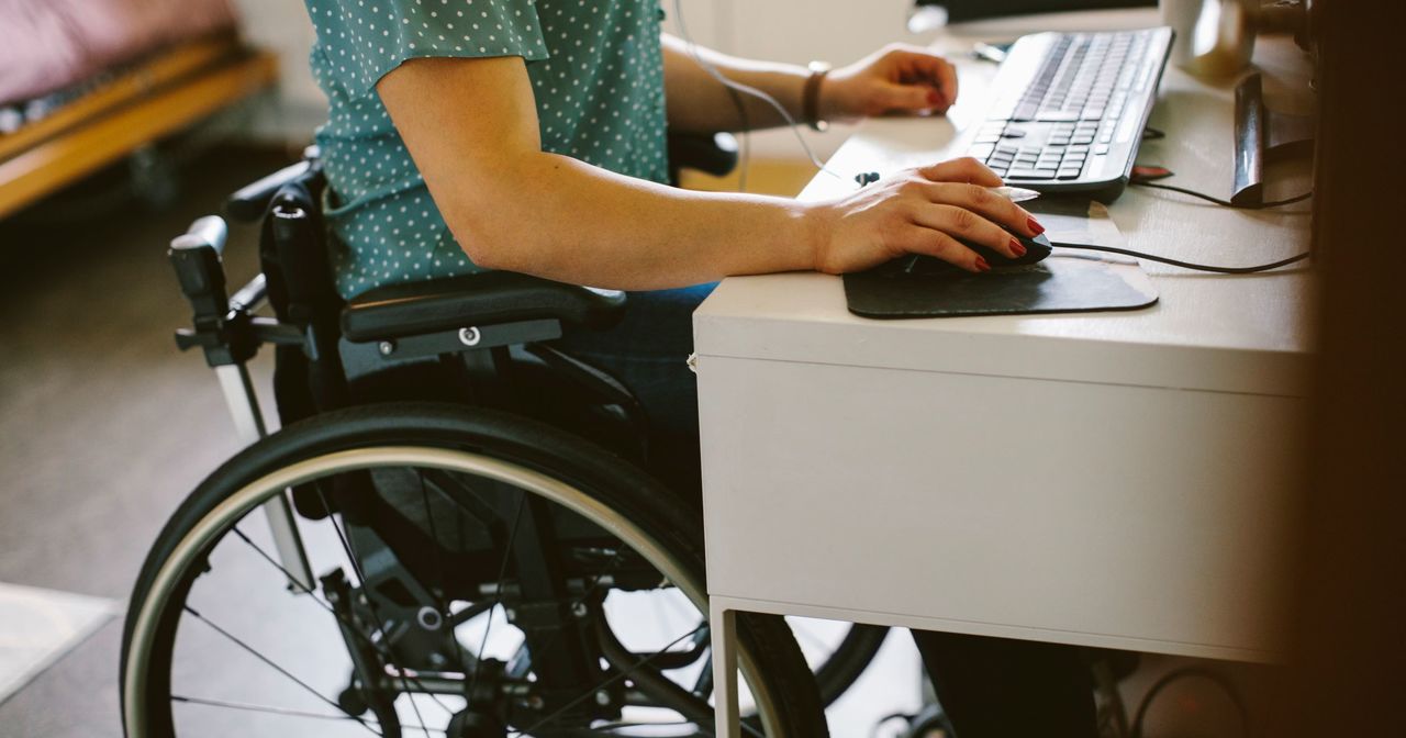 Woman in a wheelchair using her computer at a desk